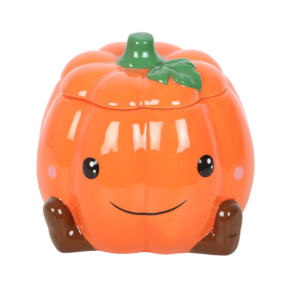 Pumpkin-shaped oil burner with a smiling face on a white background